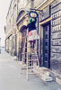 720320-029-03 Lady painting a shop sign in Budapest (Hungary)